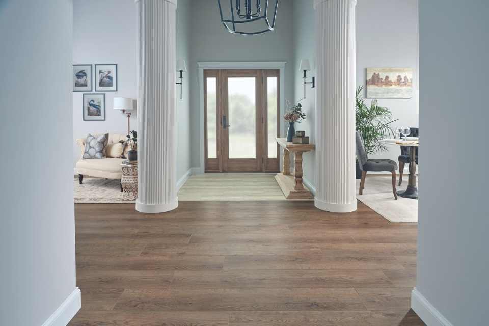 mid range wood-look luxury vinyl in grand foyer with white columns